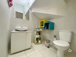 Foto de um banheiro interno com pia e vaso sanitário.