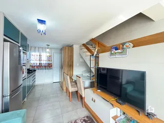 Ambiente interno de uma sala de estar com cozinha e escadaria em Lajeado, Brasil.