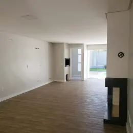 Vista interna de um ambiente amplo e vazio em uma residência.