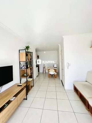 Hall de entrada com piso de cerâmica e estantes de madeira clara.