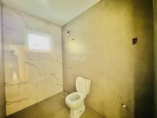 A foto mostra o interior de um banheiro com revestimento de mármore nas paredes.