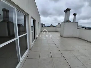 Varanda externa com piso de concreto e paredes brancas.