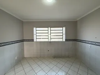 Interior de um cômodo com piso de cerâmica e paredes brancas.