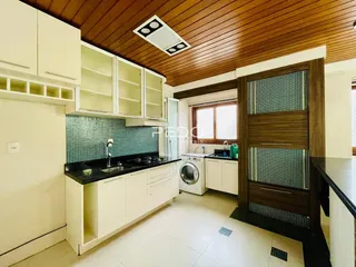 Foto de uma cozinha moderna com armários brancos e teto de madeira.