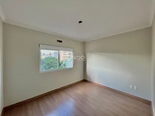 Ambiente interno com piso de madeira e grande janela.