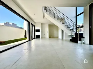 Ambiente interno moderno com piso de concreto e escadaria.