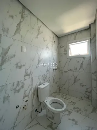 Foto de um banheiro com revestimento em mármore branco.