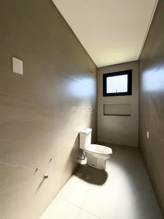 Corredor com banheiro e janela em um imóvel.