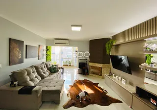 Sala de estar com sofá e piso de madeira em um imóvel no Brasil.