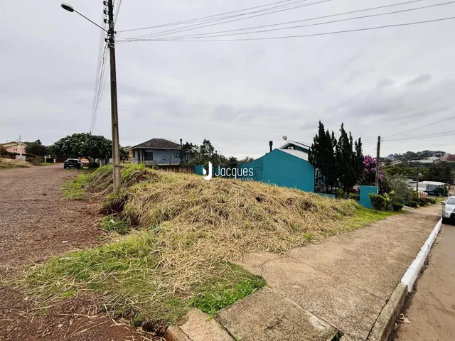 Vista externa de uma propriedade em Lajeado, Brasil, com vegetação na frente e um edifício azul ao fundo.