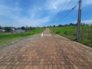 A estrada de paralelepípedos se estende por um campo gramado.