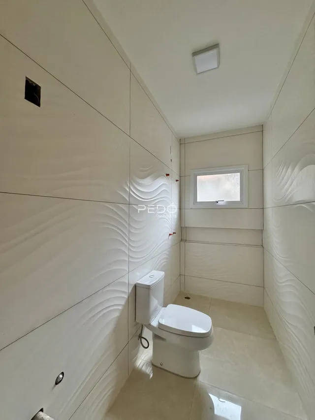 Foto de um banheiro interno com revestimento de parede em relevo.