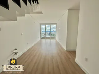 Corredor interno com piso de madeira e vista para a cidade.