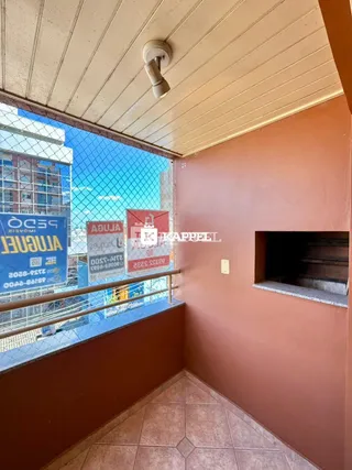 Vista de um corredor interno com vista para o exterior em um imóvel em Lajeado.