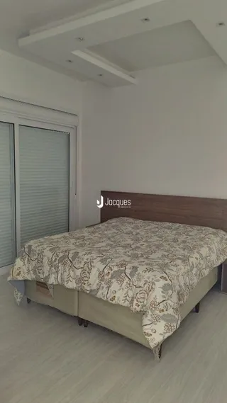 Quarto com cama de casal em ambiente claro.