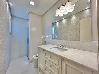 Vista de um banheiro moderno com bancada branca e azulejos na Lajeado.