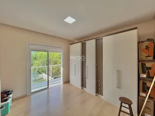 Sala de estar com piso de madeira e portas de vidro que dão para o exterior.