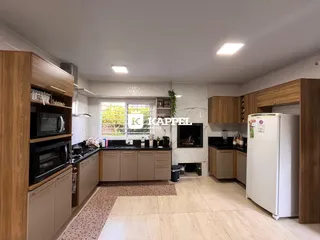 Cozinha com armários de madeira e bancadas escuras.