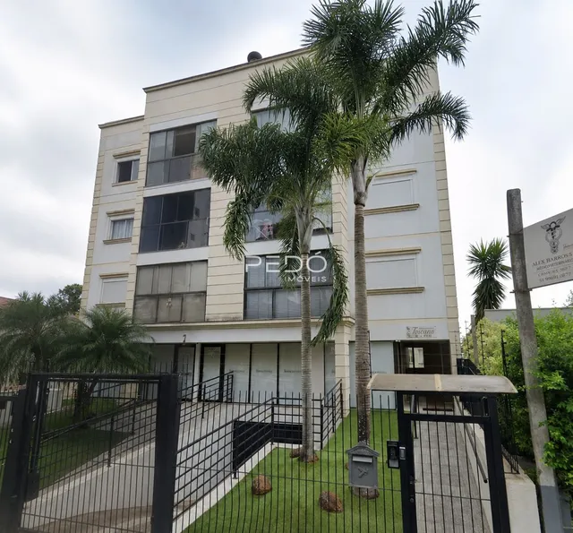 Fachada de um prédio residencial em Lajeado, Brasil, com cerca e vegetação.