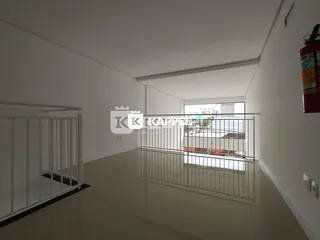 Hall de corredor com paredes brancas e grade de proteção de metal.