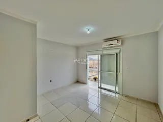 Interior de uma área com piso de cerâmica e paredes brancas.