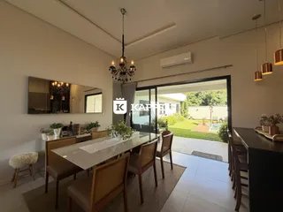Uma sala de jantar com mesa de madeira e acesso a um pátio gramado.