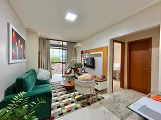 Sala de estar com sofá verde e tapete estampado em um imóvel no Brasil.