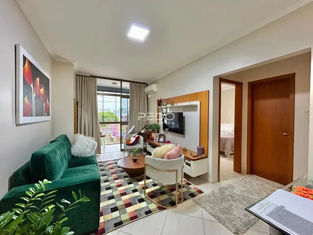 Sala de estar com sofá verde e tapete estampado em um imóvel no Brasil.