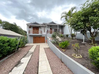 Fachada de uma residência em Lajeado, Brasil, com jardim frontal e calçada.