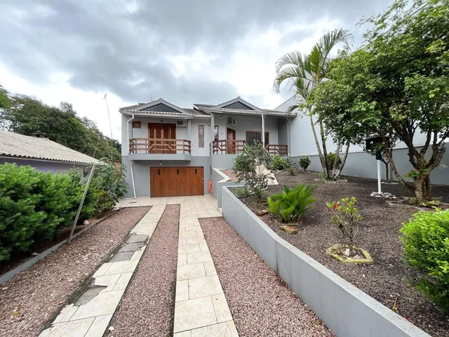 Fachada de uma residência em Lajeado, Brasil, com jardim frontal e calçada.