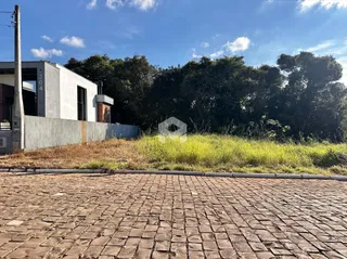 Vista da fachada de uma propriedade em Lajeado, Brasil, com vegetação alta no quintal.