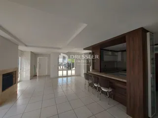 Sala de estar com piso de cerâmica clara e paredes brancas.