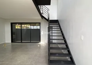 Foto de um corredor com escada em um imóvel.
