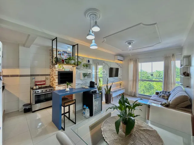 Ambiente moderno de sala de estar com cozinha integrada em Lajeado.