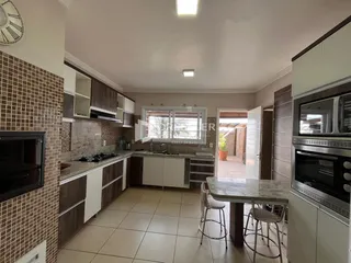 Foto de uma cozinha moderna com armários de madeira e piso de cerâmica.
