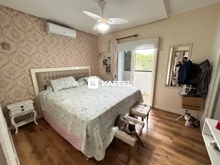 Quarto com cama de casal e decoração de parede clara.