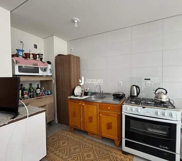 Uma cozinha com armários de madeira e bancada.