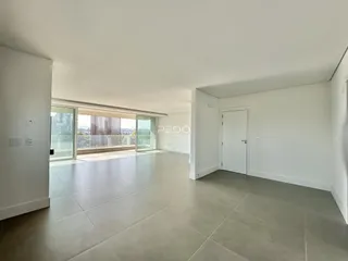 Ambiente interno de uma sala ampla com piso de cerâmica e vista para o exterior.