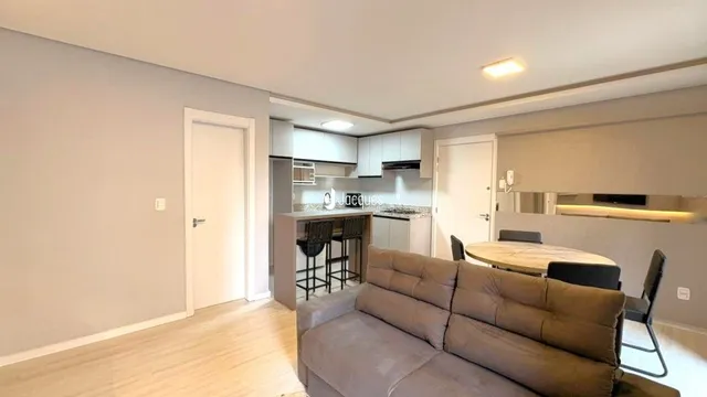 Foto de uma sala de estar com piso de madeira clara.