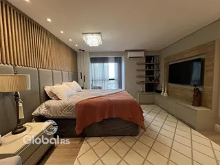 Quarto moderno com cama e televisão em um apartamento.