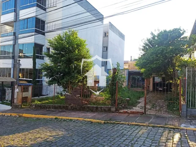 Fachada de um prédio residencial em Lajeado, Brasil, com cerca e vegetação no primeiro plano.