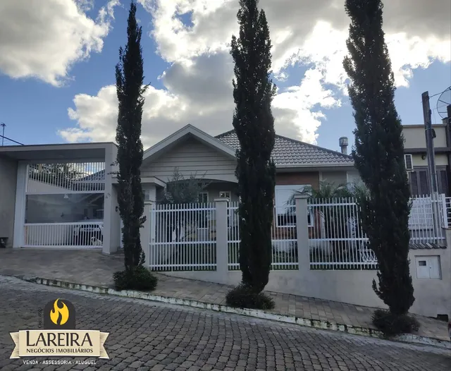 Fachada de uma residência em Lajeado, Brasil, com cerca e árvores.