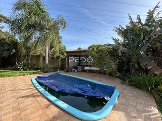 Vista externa de um quintal com área pavimentada e piscina inflável.