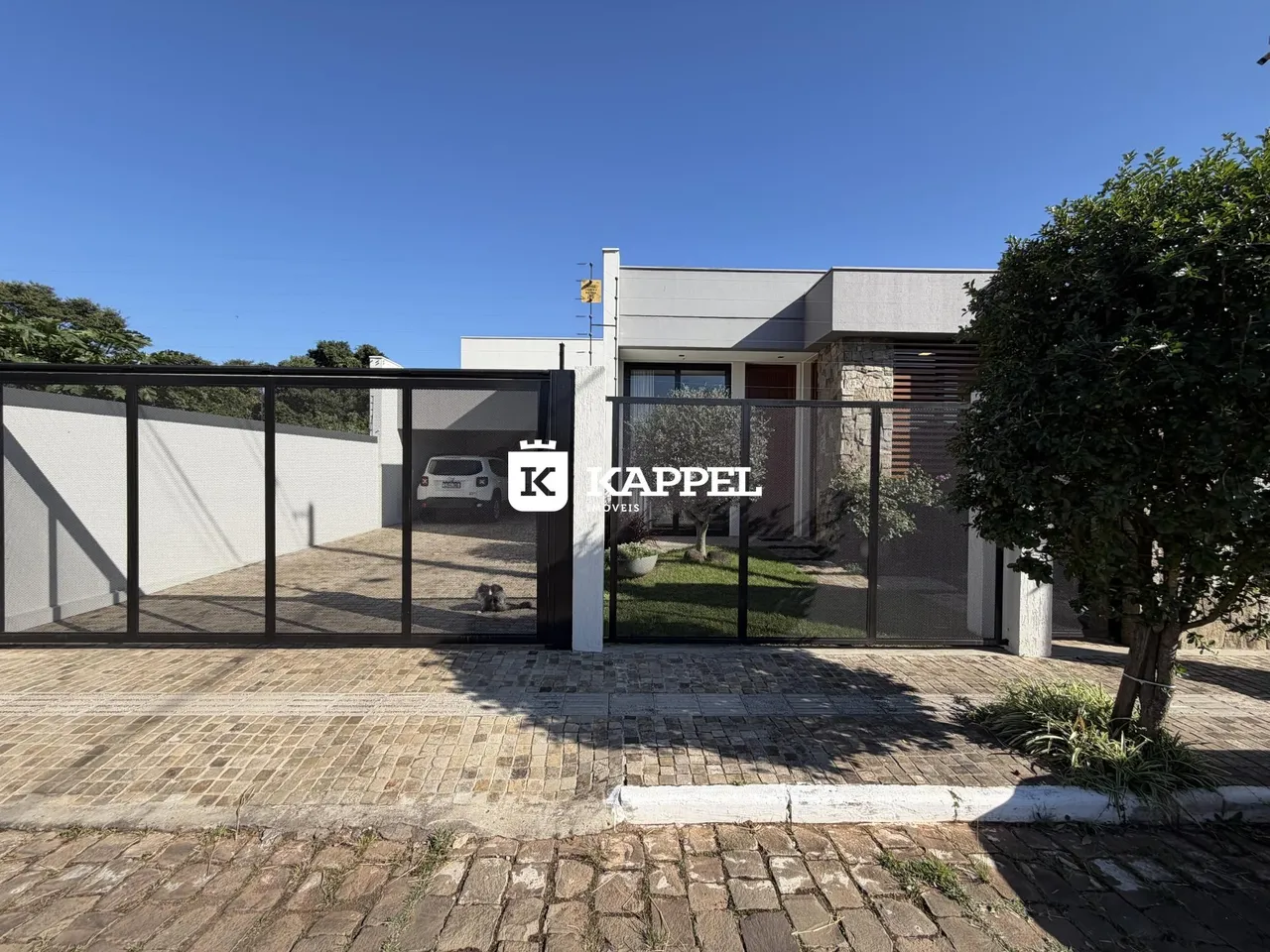 A foto mostra a fachada de uma residência com portão de segurança.