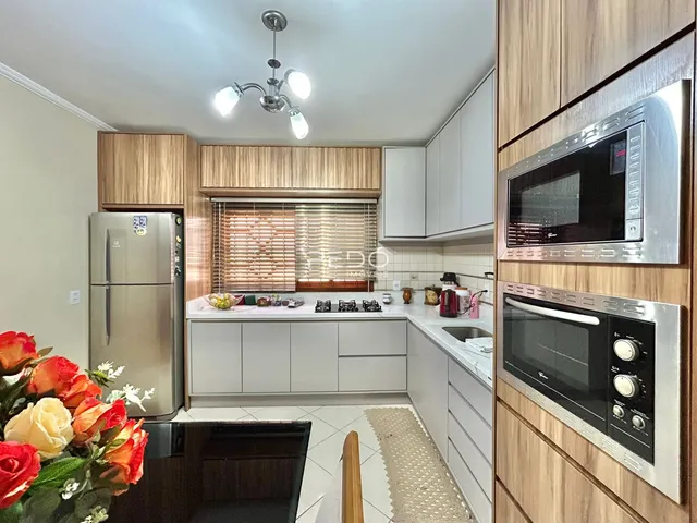 Foto de uma cozinha moderna com armários brancos e bancadas claras.