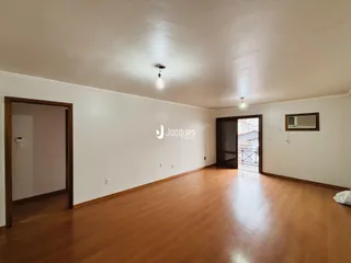 Sala de estar com piso de madeira e paredes brancas.