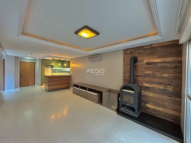 Sala de estar com piso claro e parede de madeira no interior de uma residência.