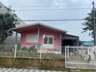 A fachada de uma casa em Lajeado, Brasil, com cerca branca.
