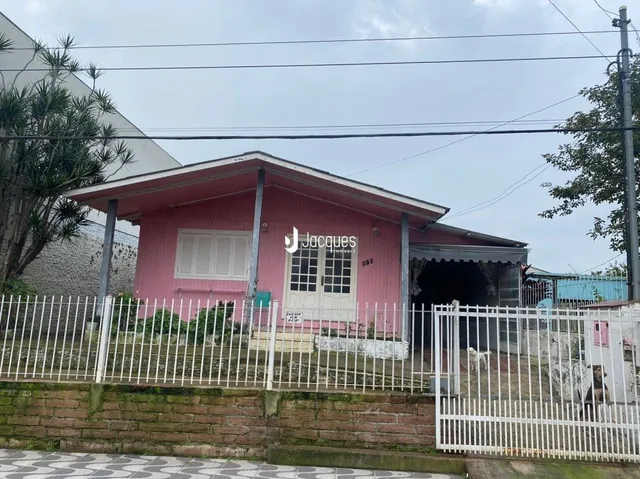 A fachada de uma casa em Lajeado, Brasil, com cerca branca.