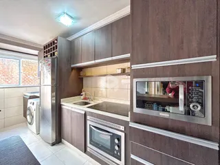 Uma cozinha moderna com armários de madeira e eletrodomésticos de aço inoxidável.